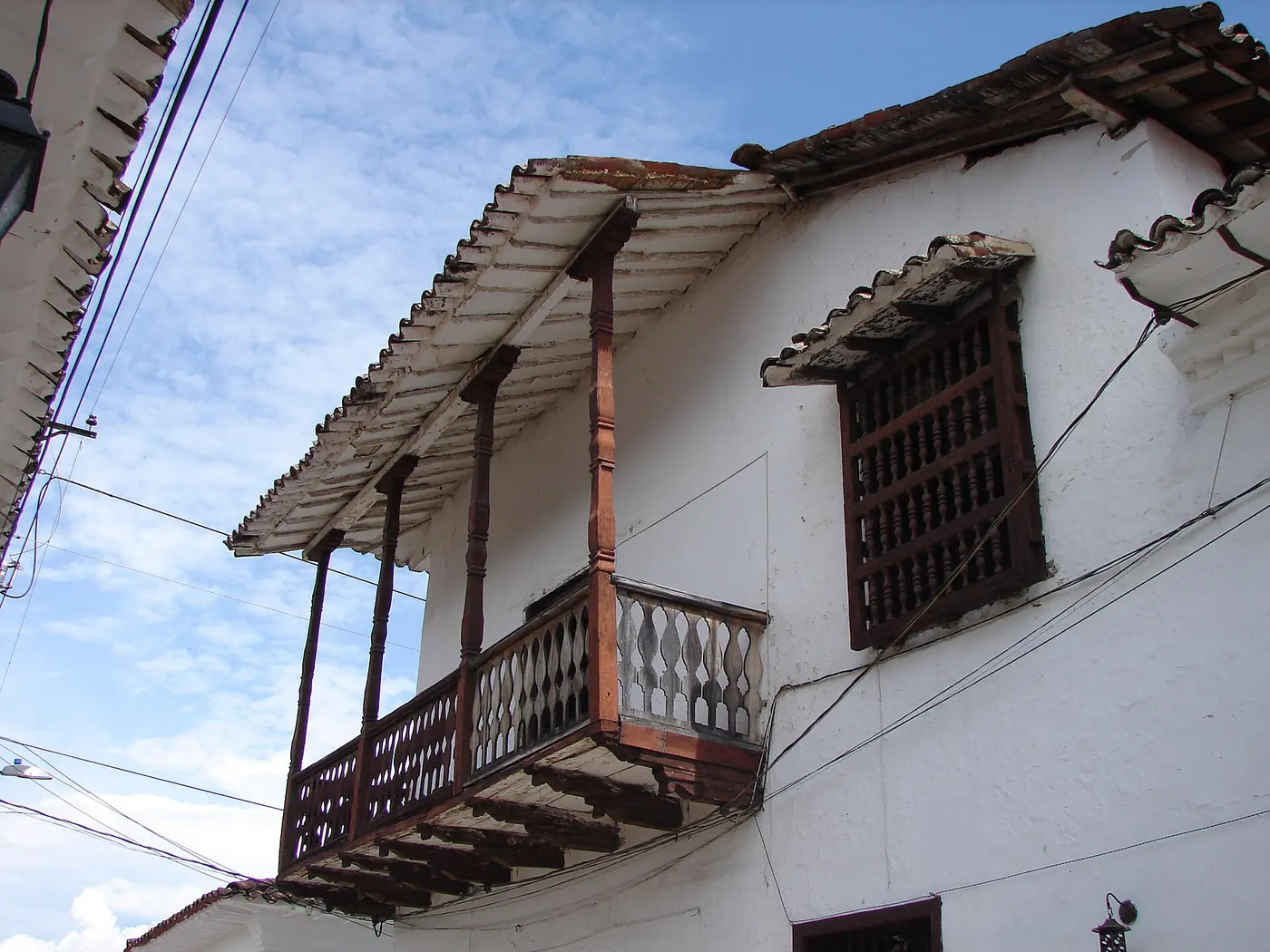 Balcón de madera oscura en una casa encalada