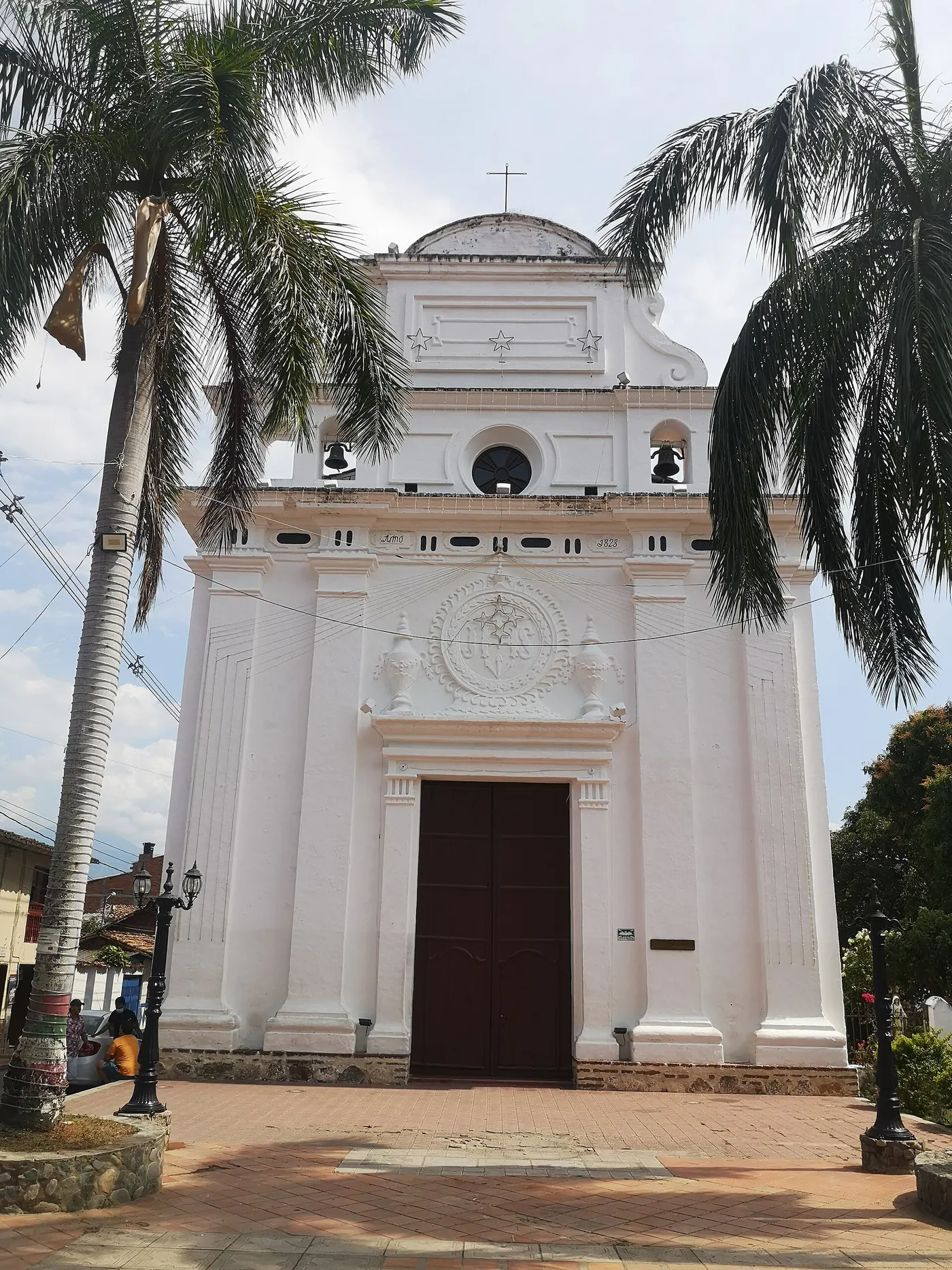 Iglesia de Jesús Nazareno, blanca, entre palmas